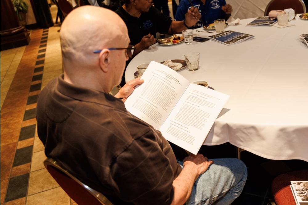 An attendee reading the program
